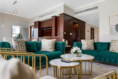 a living room with green couches and tables at Durrani Homes - Lavish 3BR Besides Burj Khalifa and Fountain view in Dubai