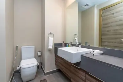 a bathroom with a white toilet and a sink at Bloom Heights: Pool, Gym & Wi-Fi - JVC - Dubai in Dubai