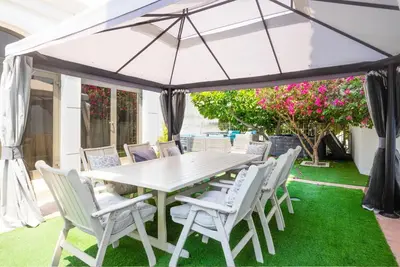 a table and chairs under an umbrella on a lawn at 6 Bedroom Modern Luxury Villa In Palm Jumeirah in Dubai