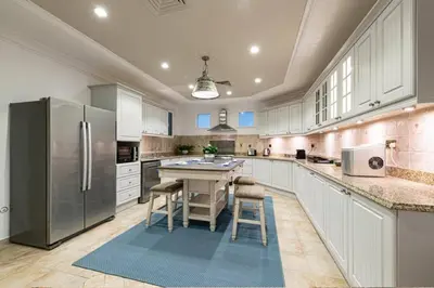 a large kitchen with white cabinets and stainless steel appliances at 6 Bedroom Modern Luxury Villa In Palm Jumeirah in Dubai