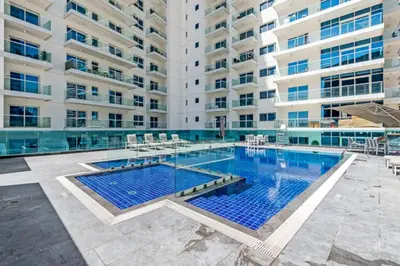 a swimming pool in front of a large building at Bright & Elegant Studio Balcony Speedy Wi-Fi in Dubai