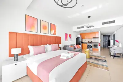 a bedroom with a large bed and a living room at StoneTree - Modern Stylish Studio in JLT in Dubai