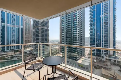 a balcony with a table and chairs and a view of the city at StoneTree - Modern Stylish Studio in JLT in Dubai