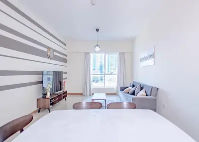 a white room with a bed and a couch at StoneTree - Spacious 1BR - Best Location for Tourist in Dubai