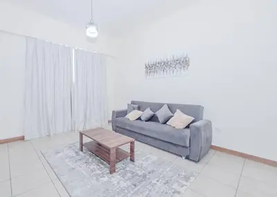 a living room with a couch and a coffee table at StoneTree - Spacious 1BR - Best Location for Tourist in Dubai
