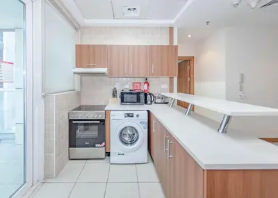 a kitchen with a washer and dryer in it at StoneTree - Spacious 1BR - Best Location for Tourist in Dubai