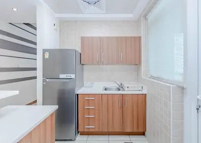 a kitchen with a sink and a refrigerator at StoneTree - Spacious 1BR - Best Location for Tourist in Dubai