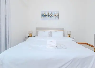 a white bed with two white towels on it at StoneTree - Spacious 1BR - Best Location for Tourist in Dubai