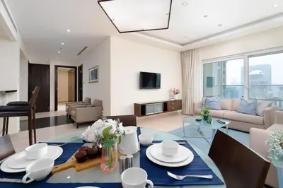 a living room with a dining table and a couch at Lovely Lake View - Two Bedroom - JLT in Dubai