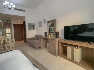 a living room with a large flat screen tv at StoneTree - Furnished Studio in Peaceful Location in Dubai