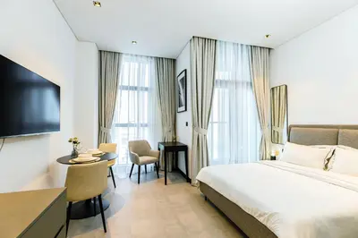 a hotel room with a bed and a table and chairs at Cozy Studio whit balcony 15NS in Dubai
