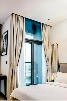 a bedroom with a bed and a large window at Cozy Studio whit balcony 15NS in Dubai