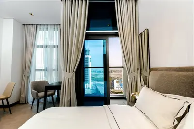a bedroom with a bed and a desk and a window at Cozy Studio whit balcony 15NS in Dubai