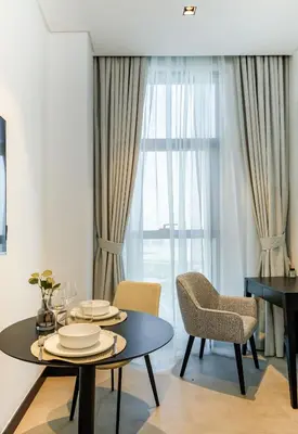 a dining room with a table and chairs and a window at Cozy Studio whit balcony 15NS in Dubai