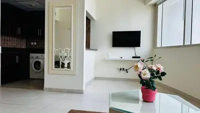 a living room with a vase of flowers on a glass table at Lakeshore Towers, Cluster Y , JLT, 1BHK in Dubai