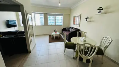 a living room with a table and a couch at Lakeshore Towers, Cluster Y , JLT, 1BHK in Dubai
