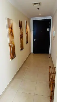 a hallway with a black door and paintings on the wall at Lakeshore Towers, Cluster Y , JLT, 1BHK in Dubai