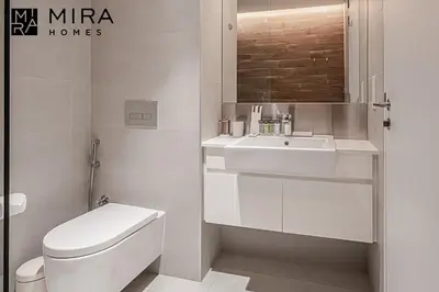a white bathroom with a toilet and a sink at Mira Holiday Homes - Serviced 1 bedroom in Bluewaters in Dubai