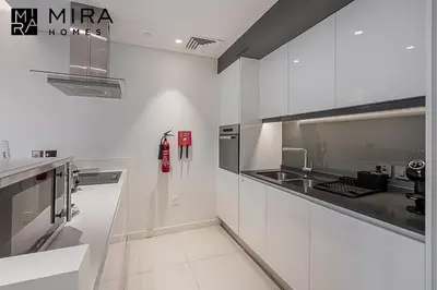 a white kitchen with a stove and a sink at Mira Holiday Homes - Serviced 1 bedroom in Bluewaters in Dubai
