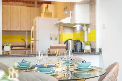 a kitchen with a table with plates and wine glasses at Marco Polo - Relax in a modern 1BR in Dubai Marina in Dubai
