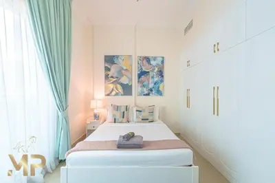 a white bedroom with a bed and a window at Marco Polo - Relax in a modern 1BR in Dubai Marina in Dubai