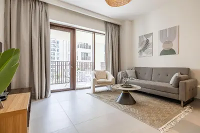 a living room with a couch and a large window at Modern 1 Bedroom Apartment I Creek Beach I Surf in Dubai