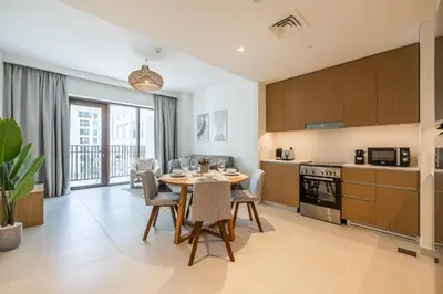 a kitchen and dining room with a table and chairs at Modern 1 Bedroom Apartment I Creek Beach I Surf in Dubai