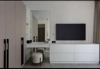 a living room with a television on a white cabinet at Mira Holiday Homes - Serviced 2 bedroom in Dubai Marina in Dubai
