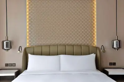 a bedroom with a bed with a large headboard at Embassy Suites By Hilton Dubai Business Bay in Dubai