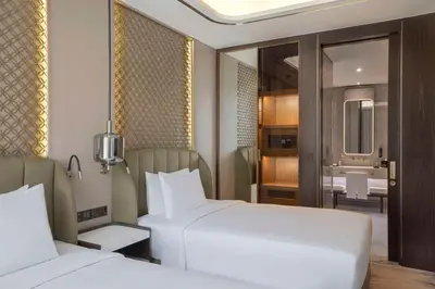 a hotel room with two beds and a bathroom at Embassy Suites By Hilton Dubai Business Bay in Dubai