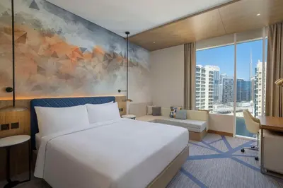 a bedroom with a white bed and a large window at Hilton Garden Inn Dubai Business Bay in Dubai