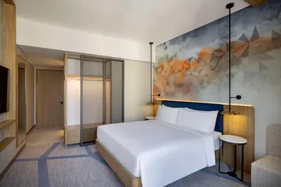 a bedroom with a white bed and a painting on the wall at Hilton Garden Inn Dubai Business Bay in Dubai