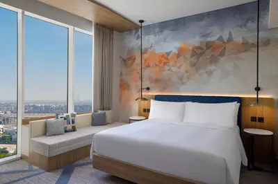 a bedroom with a large bed and large windows at Hilton Garden Inn Dubai Business Bay in Dubai