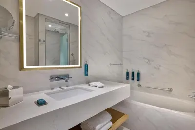 a bathroom with a sink and a tub and a mirror at Hilton Garden Inn Dubai Business Bay in Dubai