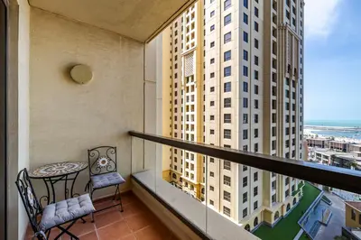 a balcony with a table and chairs and a window at Amazing 1BR With Sea View Rimal 4 JBR - NOX Holiday Homes in Dubai