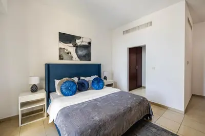 a bedroom with a large bed with blue pillows at Amazing 1BR With Sea View Rimal 4 JBR - NOX Holiday Homes in Dubai