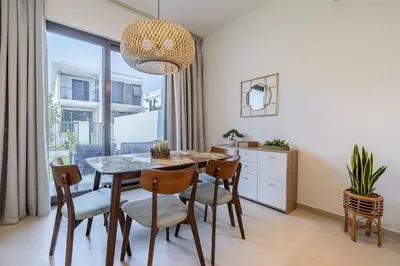 a dining room with a table and chairs at Townhouse with Garden I Tilal Al Ghaf I Elan B in Dubai