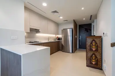 a kitchen with a refrigerator and a counter top at Townhouse with Garden I Tilal Al Ghaf I Elan B in Dubai