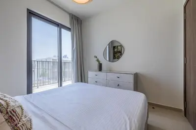 a white bedroom with a bed and a window at Townhouse with Garden I Tilal Al Ghaf I Elan B in Dubai