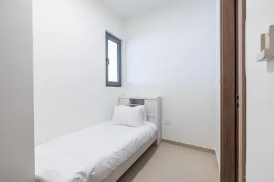 a white room with a bed and a mirror at Townhouse with Garden I Tilal Al Ghaf I Elan B in Dubai