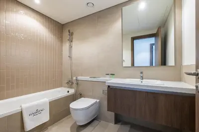 a bathroom with a toilet and a sink and a bath tub at Townhouse with Garden I Tilal Al Ghaf I Elan B in Dubai