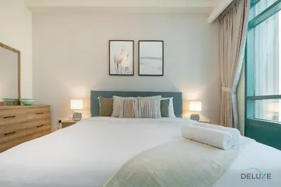 a bedroom with a large white bed and two lamps at Dazzling 1BR at Marina Crown Dubai Marina by Deluxe Holiday Homes in Dubai