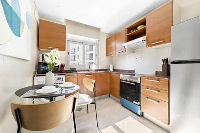 a kitchen with a table and a refrigerator at StoneTree - Cozy Studio in DEC Tower - Dubai Marina in Dubai