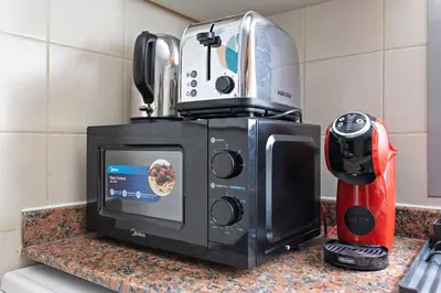 a microwave sitting on a counter next to a coffee maker at StoneTree - Cozy Studio in DEC Tower - Dubai Marina in Dubai