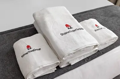 three white towels sitting on top of a bed at StoneTree - Cozy Studio in DEC Tower - Dubai Marina in Dubai