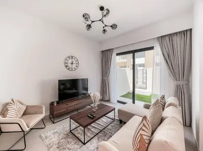a living room with a couch and a tv at StoneTree - 3 BR with 1 Maids Room Villa in Camelia - Arabian Ranches in Dubai