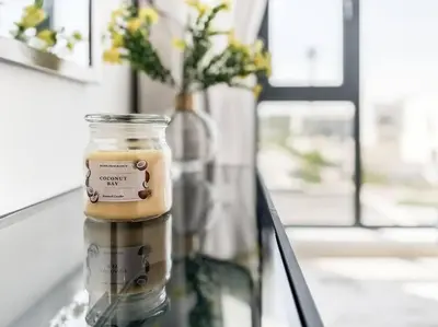 a glass jar on a table with a vase with flowers at StoneTree - 3 BR with 1 Maids Room Villa in Camelia - Arabian Ranches in Dubai