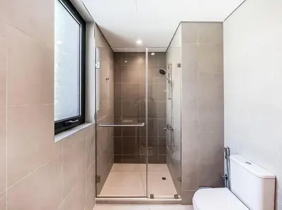 a bathroom with a shower with a toilet and a window at StoneTree - 3 BR with 1 Maids Room Villa in Camelia - Arabian Ranches in Dubai