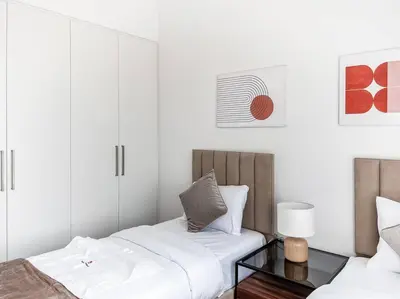 a bedroom with two beds and a glass table at StoneTree - 3 BR with 1 Maids Room Villa in Camelia - Arabian Ranches in Dubai