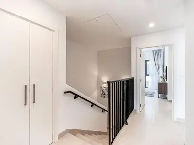 a white hallway with a staircase in a house at StoneTree - 3 BR with 1 Maids Room Villa in Camelia - Arabian Ranches in Dubai